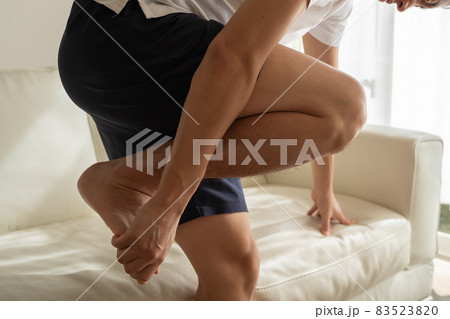 つま先を痛がる男性の様子 83523820