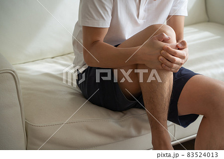 膝を抱える男性の様子 83524013