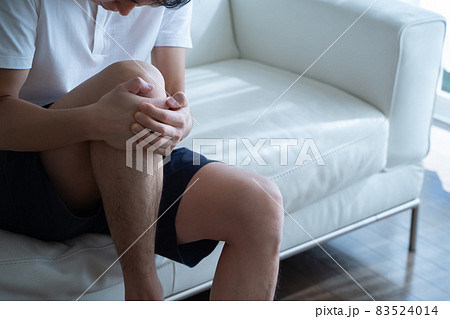 膝を抱える男性の様子 83524014