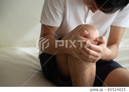 膝を抱える男性の様子 83524025
