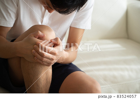 膝を抱える男性の様子 83524057