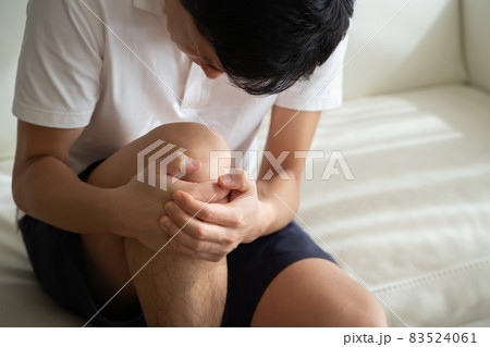 膝を抱える男性の様子 83524061