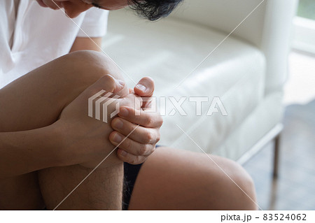 膝を抱える男性の様子 83524062