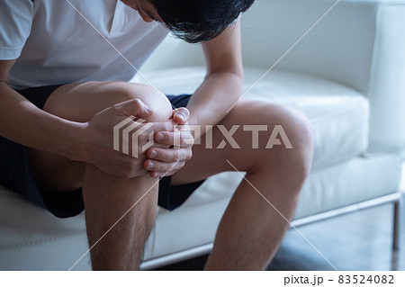 膝を抱える男性の様子 83524082