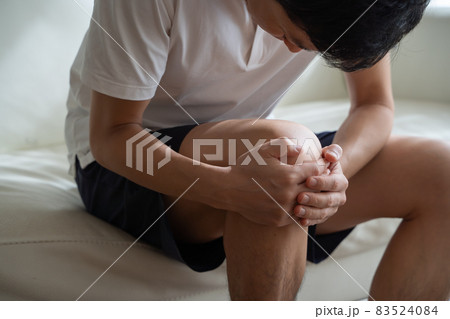 膝を抱える男性の様子 83524084