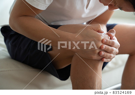 膝を抱える男性の様子 83524169