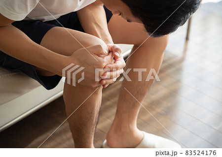 膝を抱える男性の様子 83524176
