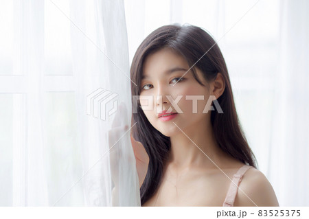 Beautiful portrait young asian woman sexy standing the window and smile while wake up with health. Beautiful portrait young asian woman sexy standing the window and smile while wake up with health. 83525375