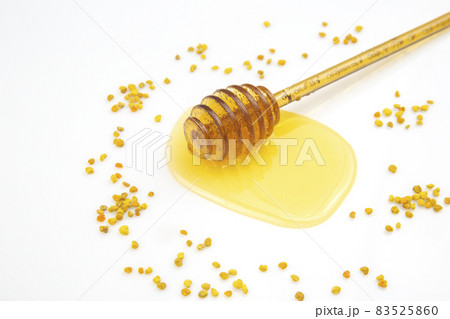 spoon with fresh honey and pollen spilled on a white background. organic vitamin food spoon with fresh honey and pollen spilled on a white background. organic vitamin food 83525860