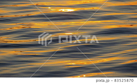 Reflection of the setting sun in a wave of water. Natural background texture Reflection of the setting sun in a wave of water. Natural background texture 83525870