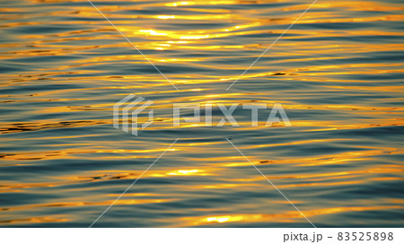 Reflection of the setting sun in a wave of water. Natural background texture Reflection of the setting sun in a wave of water. Natural background texture 83525898