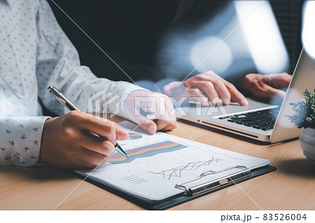 Two colleagues discussing data with tablet and new modern computer laptop on desk table. Close up business team analysis and strategy concept. 83526004