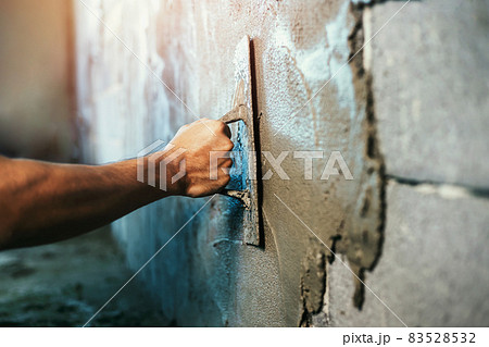 closeup hand of worker plastering cement at wall for building house 83528532