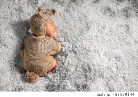 Back view happy newborn baby weaing cute rabbit costume lying sleep on grey carpet background comfortable with copy space.Cute Asian infant sleeping napping on baby bed.Newborn Baby Easter Day Concept 83529144