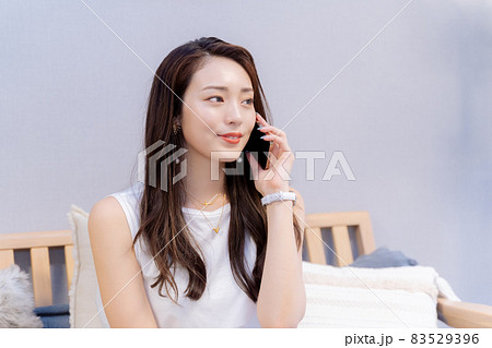 スマホ通話で相手の話を聞く女性 83529396