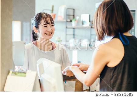 受付で接客を受ける女性 83531085