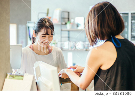 受付で接客を受ける女性 83531086