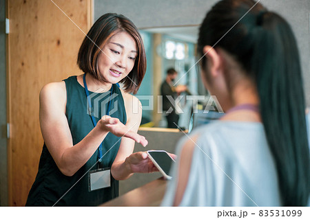 スポーツジムのフロントにいる女性（スマホ） 83531099