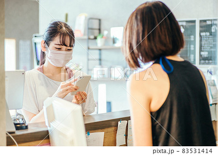 受付でスマホを出す女性(マスク) 受付でスマホを出す女性(マスク) 83531414