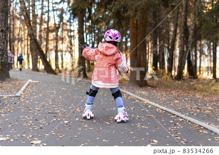 5 year old little girl roller skating in autumn park 83534266