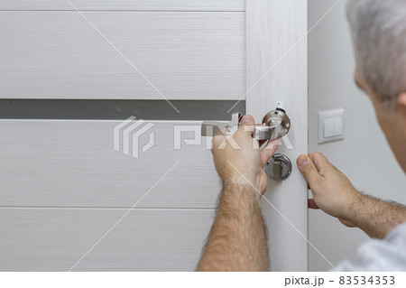 man changing the door lock at home 83534353