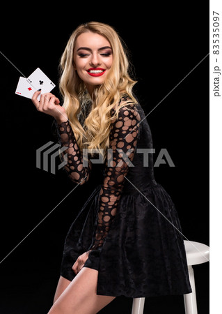 Beautiful confident woman sitting on chair showing cards looking at camera with copy place Beautiful confident woman sitting on chair showing cards looking at camera with copy place 83535097