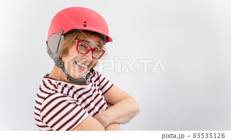 Happy elderly woman in goggles and pink ski helmet on a white background Happy elderly woman in goggles and pink ski helmet on a white background 83535126