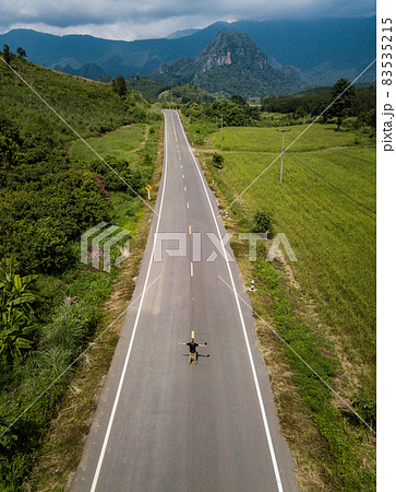 Aerial view of tourist standing on Route 1148 road, a winding mountain road that links the northern Thai provinces of Nan and Phayao. 83535215