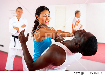 Men and woman training self-protection martial arts in gym 83536094