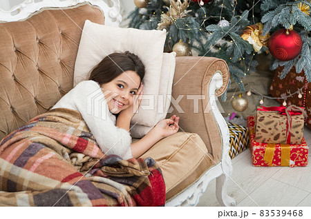 Dreaming about gifts. Little girl lay on couch near christmas Dreaming about gifts. Little girl lay on couch near christmas 83539468