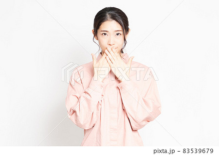 口に手を当てて内緒のジェスチャーをする女性 83539679