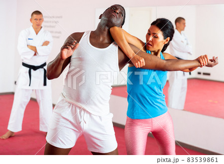 Portrait of woman during self-defense training at sports club. Sparring with male partner Portrait of woman during self-defense training at sports club. Sparring with male partner 83539861
