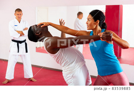 Self-defense lesson - woman strikes painful blow in eyes of man 83539885