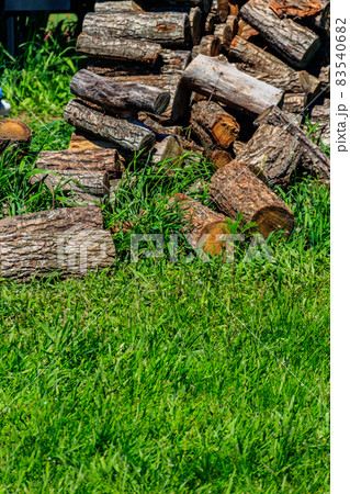 Pile of firewood on a green lawn at backyard 83540682