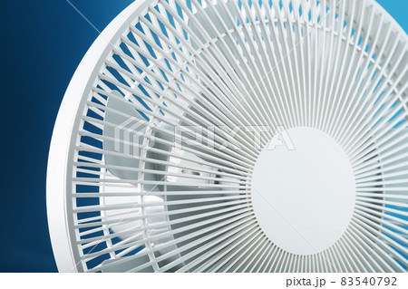 The grille and blades of the electric fan are white on a blue background The grille and blades of the electric fan are white on a blue background 83540792