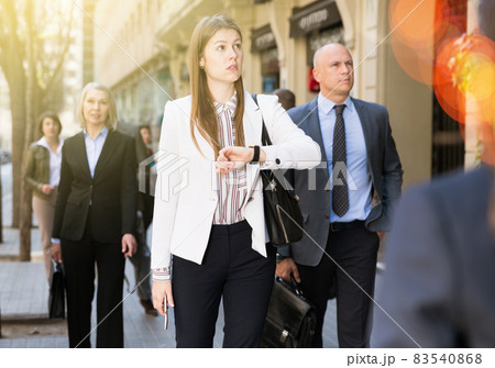 Portrait of hurrying woman among passers 83540868