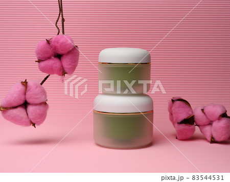 green jar for cosmetics on a pink background. Packaging for cream, gel, serum, advertising and product promotion 83544531