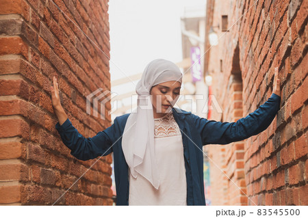 Portrait of female model in fashionable hijab style posing on urban background. Stylish Muslim woman hijab fashion lifestyle portraiture concept. Portrait of female model in fashionable hijab style posing on urban background. Stylish Muslim woman hijab fashion lifestyle portraiture concept. 83545500