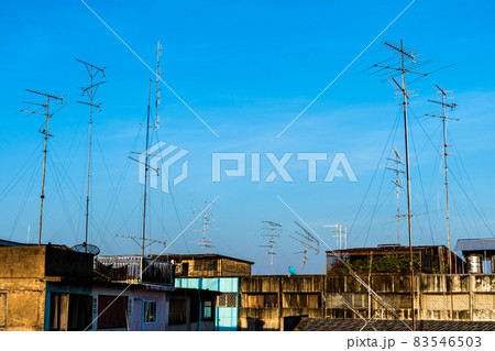 Old style Television (TV) Antenna and satellite on the roof with the house or building in provincial area in blue sky with cloud Background in Thailand,Analog TV receiver panels Old style Television (TV) Antenna and satellite on the roof with the house or building in provincial area in blue sky with cloud Background in Thailand,Analog TV receiver panels 83546503