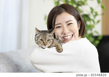 リビングで猫を抱く女性 リビングで猫を抱く女性 83546820