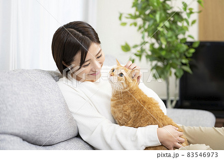 リビングで猫を抱く女性 リビングで猫を抱く女性 83546973