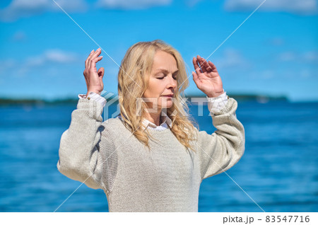 Woman relaxed with raised arms outdoors 83547716