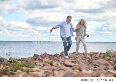 Man and woman walking by hand near sea 83548183