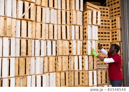 African american man stacking wooden crates 83548549