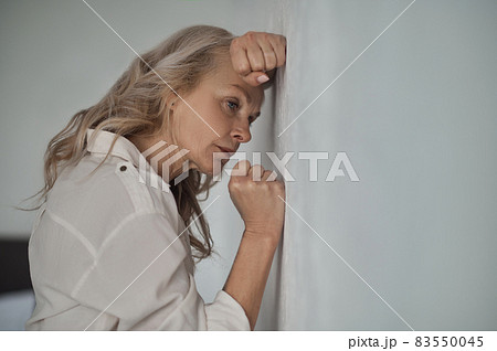 Dejected mature blonde woman suffering from loneliness 83550045