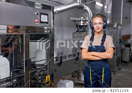 Serious industrial female engineer in spectacles standing in factory at work place 83551154