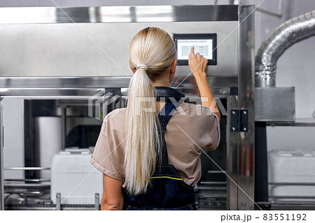 experienced factory worker turn on the robotic line for pesticides bottling and packing 83551192