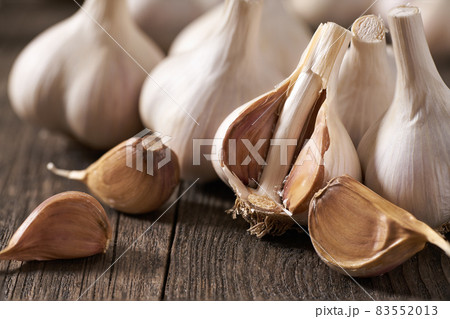 Garlic cloves and bulbs on a vintage wooden table, close up. Garlic cloves and bulbs on a vintage wooden table, close up. 83552013