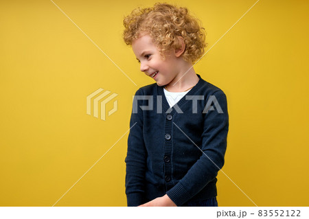 Nice preschool boy posing isolated over yellow studio background. Curly kid 83552122