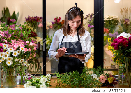 people, business, technology, sale and floristry and concept. florist woman with tablet pc people, business, technology, sale and floristry and concept. florist woman with tablet pc 83552214